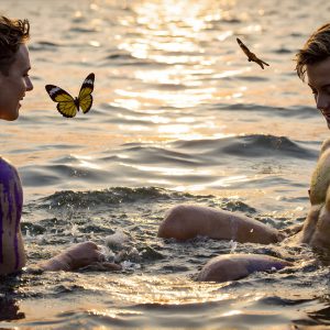 The Beautiful & Handsome Men Art Collection, A high-resolution photograph of two handsome best friends, half submerged in water, covered in body paint. Butterfly's flying about, as they spend time together, with a smile on their faces.