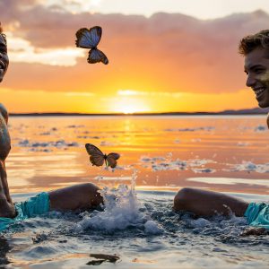 The Beautiful & Handsome Men Art Collection, A high-resolution photograph of two handsome best friends, half submerged in water, covered in body paint. Butterfly's flying about, as they spend time together, with a smile on their faces.