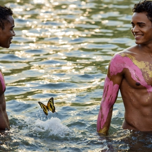 The Beautiful & Handsome Men Art Collection, A high-resolution photograph of two handsome best friends, half submerged in water, covered in body paint. Butterfly's flying about, as they spend time together, with a smile on their faces.