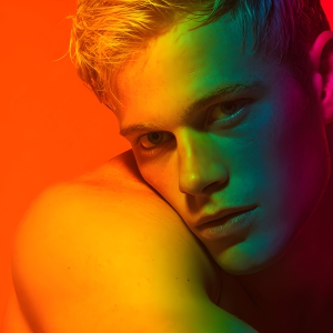 AI-generated art capturing men in a rainbow of colors creates a striking visual impact, blending surreal, vibrant, and high-fashion elements. Featuring artwork of beautiful, shirtless, muscular men embellished with or surrounded by a vibrant rainbow palette, evoking themes of pride, vitality, and artistic expression.