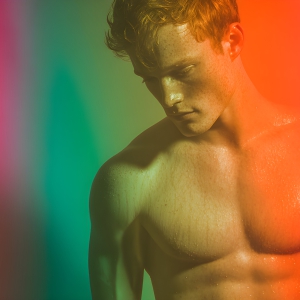 AI-generated art capturing men in a rainbow of colors creates a striking visual impact, blending surreal, vibrant, and high-fashion elements. Featuring artwork of beautiful, shirtless, muscular men embellished with or surrounded by a vibrant rainbow palette, evoking themes of pride, vitality, and artistic expression.