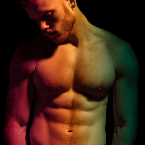 AI-generated art capturing men in a rainbow of colors creates a striking visual impact, blending surreal, vibrant, and high-fashion elements. Featuring artwork of beautiful, shirtless, muscular men embellished with or surrounded by a vibrant rainbow palette, evoking themes of pride, vitality, and artistic expression.