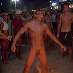 Bad Boys Naked Beach Party II. A full-body composition of a nude young man standing near a crackling bonfire, on a serene moonlit night at the beach. The gentle glow of the flames, flickers across his shinny wet body, catching his contours, and highlighting his muscular physique and handsome face. People everywhere partying, dancing to the music, having a good time together, naked, and free.