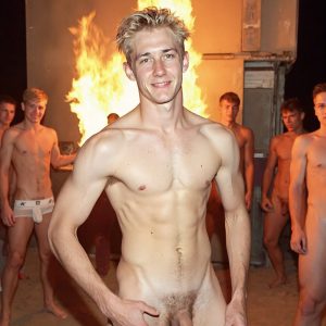 Bad Boys Naked Beach Party II. A full-body composition of a nude young man standing near a crackling bonfire, on a serene moonlit night at the beach. The gentle glow of the flames, flickers across his shinny wet body, catching his contours, and highlighting his muscular physique and handsome face. People everywhere partying, dancing to the music, having a good time together, naked, and free.